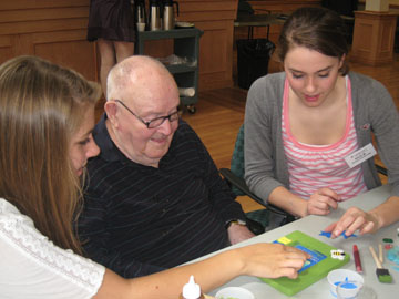 Intergenerational volunteers decorate a picture frame