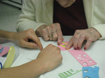 A senior and a student making an Easter egg