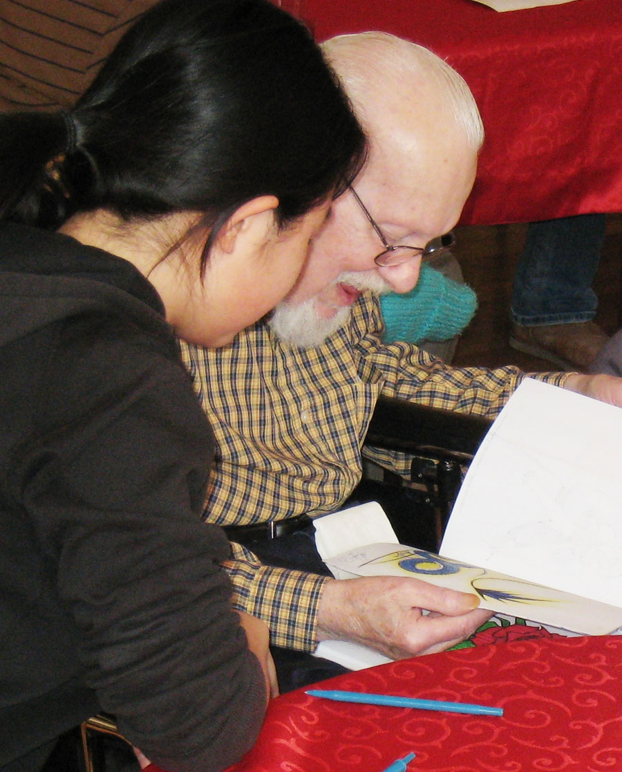 Intergenerational program volunteers reading a book
